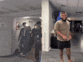 a group of people standing in a hallway next to a sign that says ' unisex ' on it