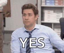 a man in a blue shirt and tie is sitting in an office and says yes