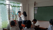 a group of students in a classroom with a sign on the wall that says " social distancing " on it