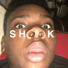 a close up of a person 's face with the word shook written above it