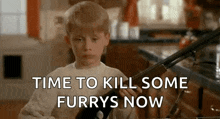 a young boy is holding a shotgun in a kitchen .