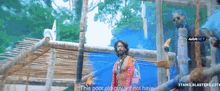 a man in a colorful costume stands in front of a wooden structure and says " this poor old guy will not have ... "