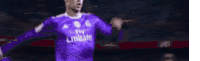 a soccer player is wearing a purple fly emirates jersey and celebrating a goal .
