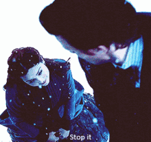 a man and a woman are standing in the snow and the man is saying stop it
