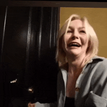 a woman is laughing in front of a door .