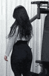 a woman with long black hair is standing in front of a machine that says lg on it