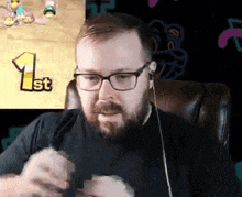 a man wearing glasses sits in front of a screen with the number 1 on it