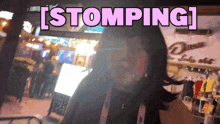 a woman stands in front of a store that says stomping on it