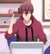 a man in a red hoodie is pointing up