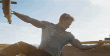 a man with his arms outstretched is sitting on a concrete surface