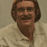 a man wearing glasses and a white shirt with the letter o on the front