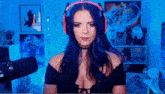 a woman wearing headphones and a choker is sitting in front of a microphone in a room .