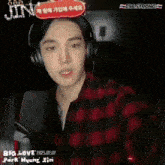 a young man wearing headphones stands in front of a microphone ..