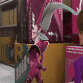 a cartoon character in a pink and purple outfit with a very long hat