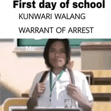 a man in a school uniform is giving a thumbs up in front of a chalkboard .