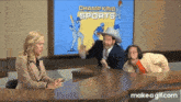 a man in a cowboy hat is talking to a woman in front of a screen that says " champ kind sports "