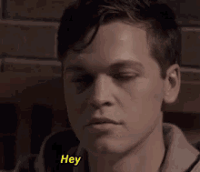 a close up of a man 's face with the word hey in yellow letters