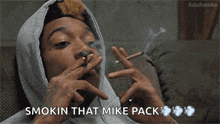 a man in a hoodie smoking a cigarette with the words smokin that mike pack below him
