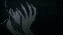 a man with long nails covering his face with his hands