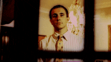 a man in a white shirt and tie with a diamond pattern