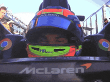 a man wearing a jack daniels helmet is in a mclaren race car