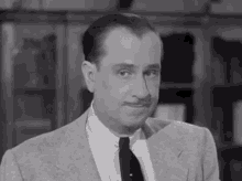 a man wearing a suit and tie looks at the camera