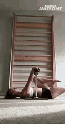 a woman is doing exercises on a pole in front of a wooden wall that says " awesome "
