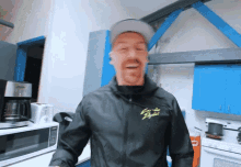 a man in a kitchen wearing a jacket that says santa fe express