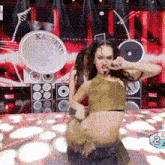 a woman is singing into a microphone on a stage with a drum that says k & n on it