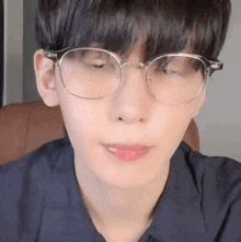 a close up of a man wearing glasses and a black shirt .