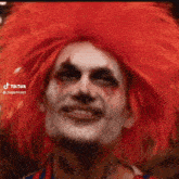a close up of a person wearing a clown costume with red hair .