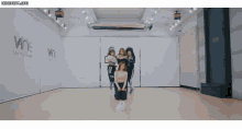 a group of women are kneeling down in a dance studio