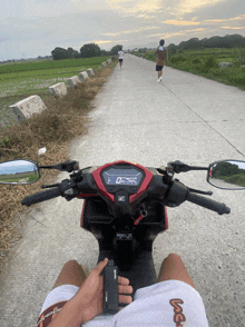 a person sitting on a honda scooter holding a cell phone
