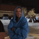 a man wearing a blue hoodie is standing in front of a tent