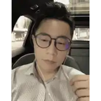 a man wearing glasses is sitting in a car with headphones