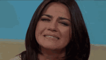 a woman with a ring on her finger is crying with her eyes closed .
