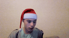 a man wearing a santa hat is making a hand gesture