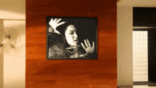 a framed picture of a woman 's face is hanging on a wall