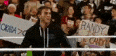 a man in a wrestling ring is holding a sign that says randy is the candy .
