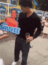 a man holding a sign that says shuvee on it