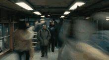 a blurry picture of people walking in a hallway with a sign that says ' exit ' on it