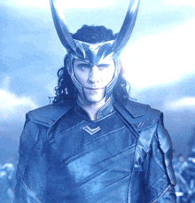 a man wearing a helmet with horns on his head looks at the camera