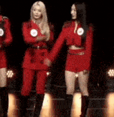 a group of women are standing next to each other on a stage and holding hands .