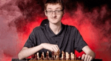 a young man is playing a game of chess on a chess board .