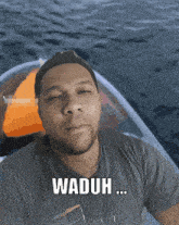 a man in a boat with the words waduh written on his shirt