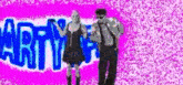 a man and a woman are standing next to each other in front of a sign that says arty .