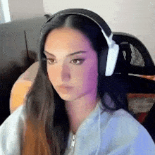 a woman wearing headphones is sitting in a chair in front of a computer .