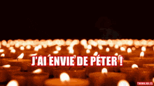 a bunch of lit candles with the words j'ai envie de peter in red