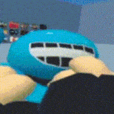 a close up of a blue stuffed animal with a white face and a mouth .