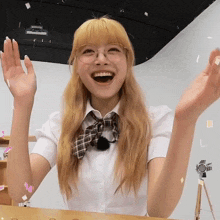 a girl wearing glasses and a plaid bow tie is laughing
